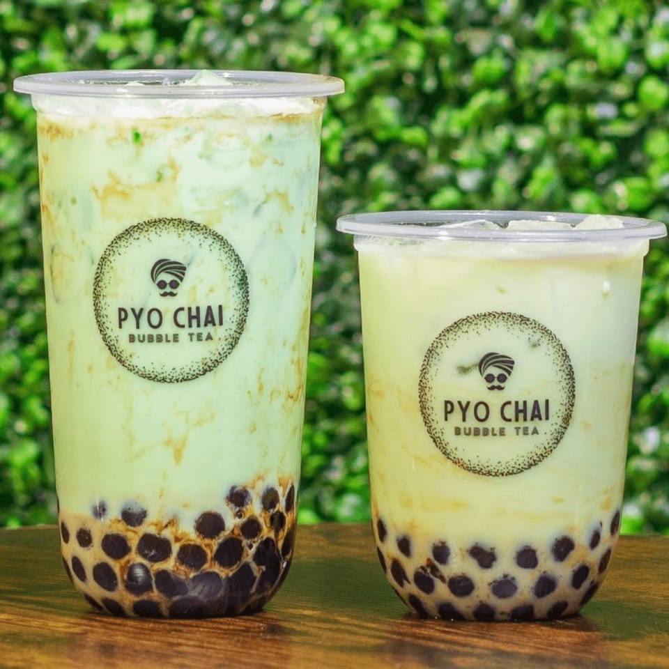 Two PYO CHAI boba drinks, one tall and one short, with tapioca pearls and light green liquid.