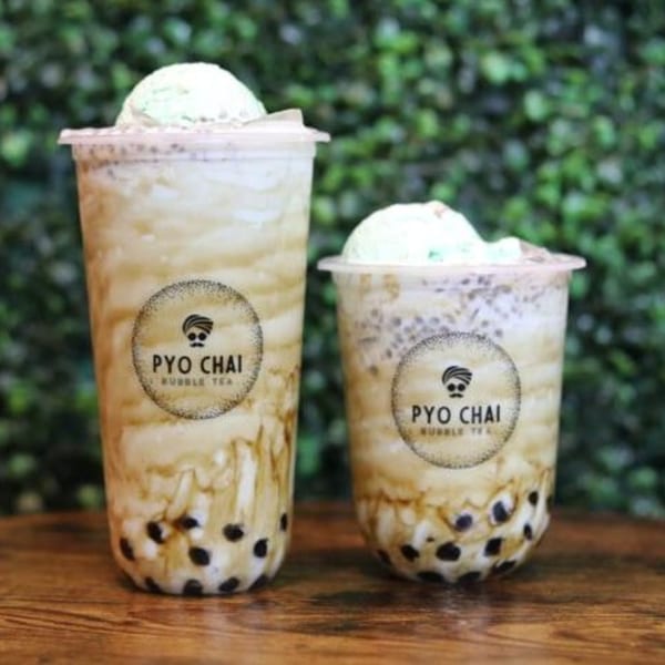 Two PYO Chai boba drinks with green ice cream scoops, against a green leafy background.