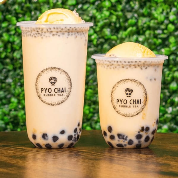 Two PYO Chai boba drinks with tapioca pearls and a scoop of ice cream on top.
