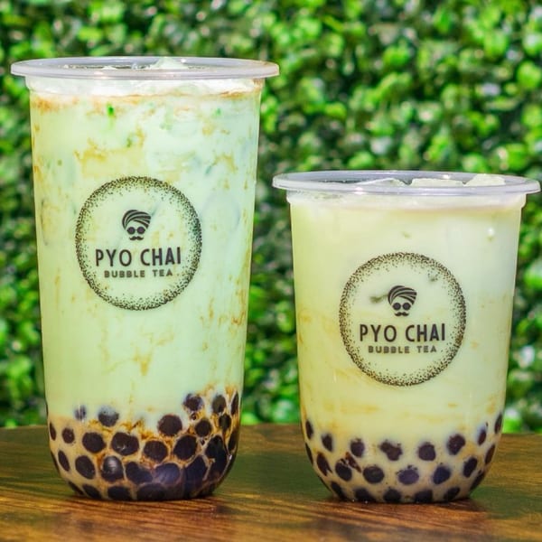 Two PYO Chai boba drinks, one light green and one pale yellow, with tapioca pearls.